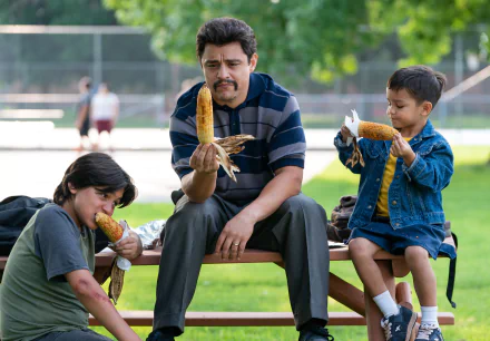 Family enjoying corn on the cob at a park on a sunny day, a perfect Flamin' Hot themed HD desktop wallpaper and background.