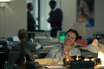 HD desktop wallpaper featuring an individual relaxing in an office setting, giving off a laid-back air amidst busy surroundings.