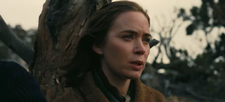 Emily Blunt in a poignant moment from the movie Oppenheimer. This HD desktop wallpaper captures her expressive performance against a somber backdrop.