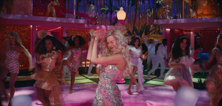 A vibrant scene from the movie *Barbie* (2023) featuring Margot Robbie dancing joyfully among a colorful cast, set against a dazzling party backdrop.