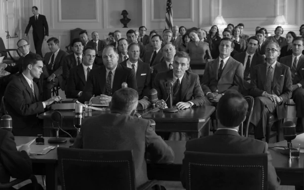 Black and white HD desktop wallpaper featuring a historical setting with a group of men in suits at what appears to be a government hearing, tagged with Oppenheimer.