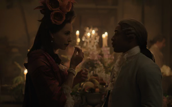 HD desktop wallpaper featuring an elegant scene with two people in historical Chevalier-style costumes, conversing intimately in a candlelit room adorned with flowers and a chandelier.