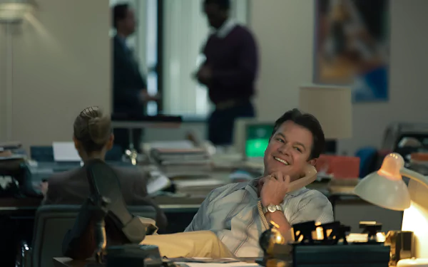 HD desktop wallpaper featuring an individual relaxing in an office setting, giving off a laid-back air amidst busy surroundings.