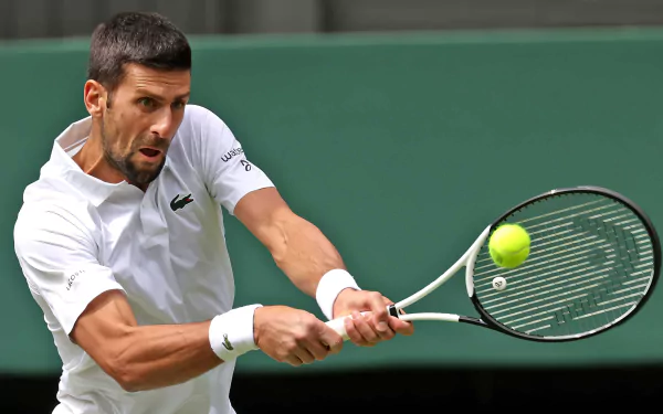Tennis player in white at Wimbledon 2023 delivering a powerful backhand shot - HD desktop wallpaper.