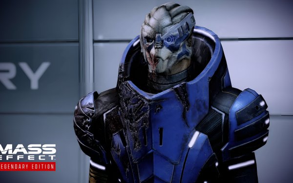 HD wallpaper of a character from Mass Effect Legendary Edition with a blue armored suit standing in front of a metallic surface with game logo visible.