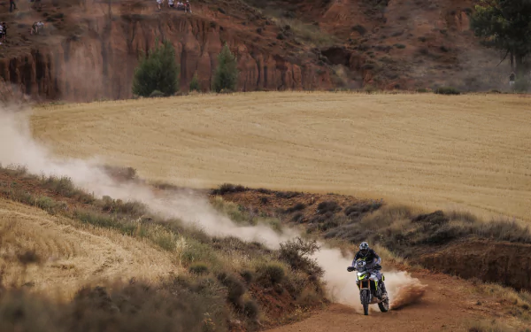 Triumph Tiger 900 Rally Pro motorcycle riding on off-road trail with dust trail in the background - HD desktop wallpaper