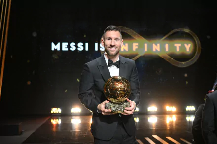 HD desktop wallpaper featuring a sports personality in a suit, holding a golden trophy at an award ceremony, with the caption Messi is Infinity in the background.