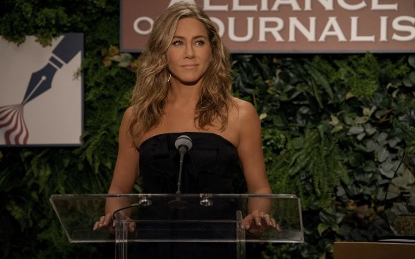 Woman at a podium at an 'Alliance of Journalists' event, likely from a scene related to 'The Morning Show'—ideal for use as HD desktop wallpaper and background.