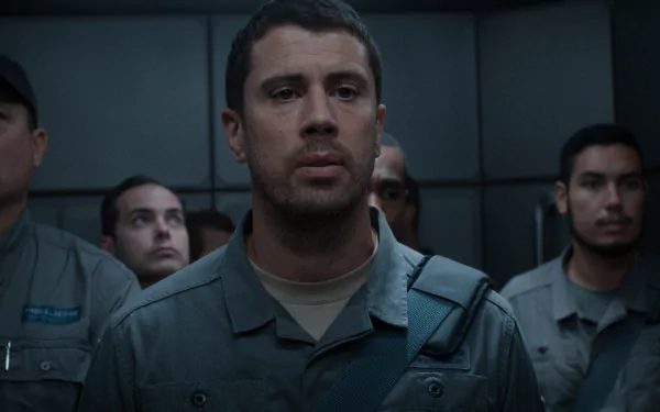 HD wallpaper featuring a scene from For All Mankind with a focused man in uniform foreground and fellow personnel in background.