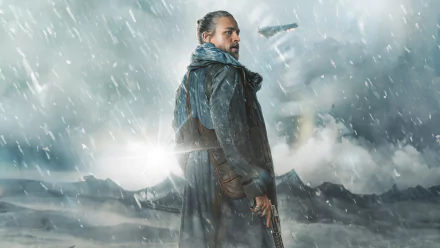 A character stands in a stormy landscape, wearing a dark cloak and holding a weapon, from the movie Rebel Moon. This HD image serves as a striking desktop wallpaper.