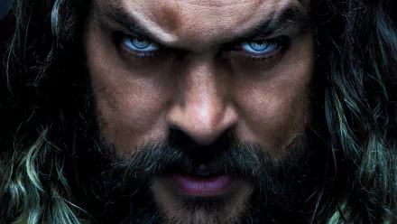 Close-up of Jason Momoa portraying Aquaman from Aquaman and The Lost Kingdom, featuring intense expression and striking blue eyes, designed as an HD desktop wallpaper and background.