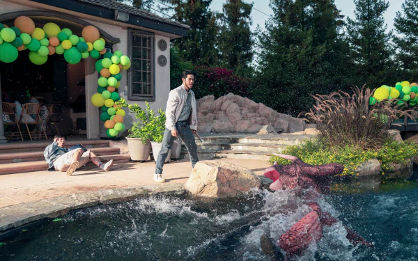 HD wallpaper featuring a scene from the TV show The Brothers Sun with two characters by a pool, one falling into the water and another walking with a pensive expression, amidst a festive setting with balloons.