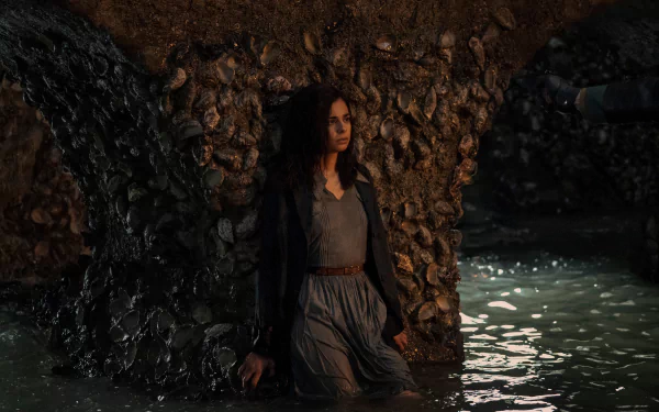 HD wallpaper featuring a scene from 'All the Light We Cannot See' TV show, depicting a mysterious character by the water.