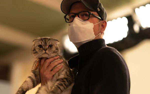 HD desktop wallpaper from the movie Argylle featuring a person in glasses and a mask holding a cat.