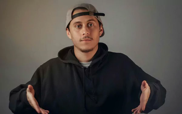 A striking HD wallpaper featuring Canserbero, showcasing him in a casual pose with a thoughtful expression, making a compelling addition to any music-themed background.