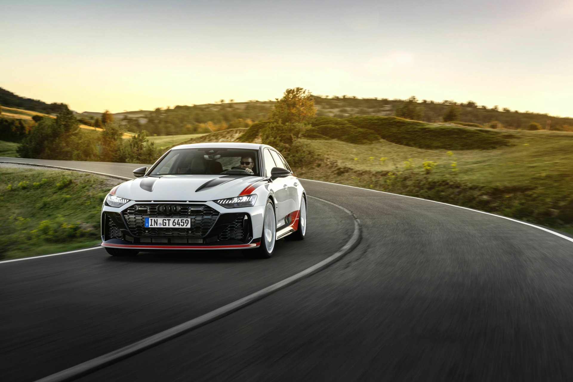Audi RS6 Avant GT speeding along a curve on a scenic road, HD desktop wallpaper.