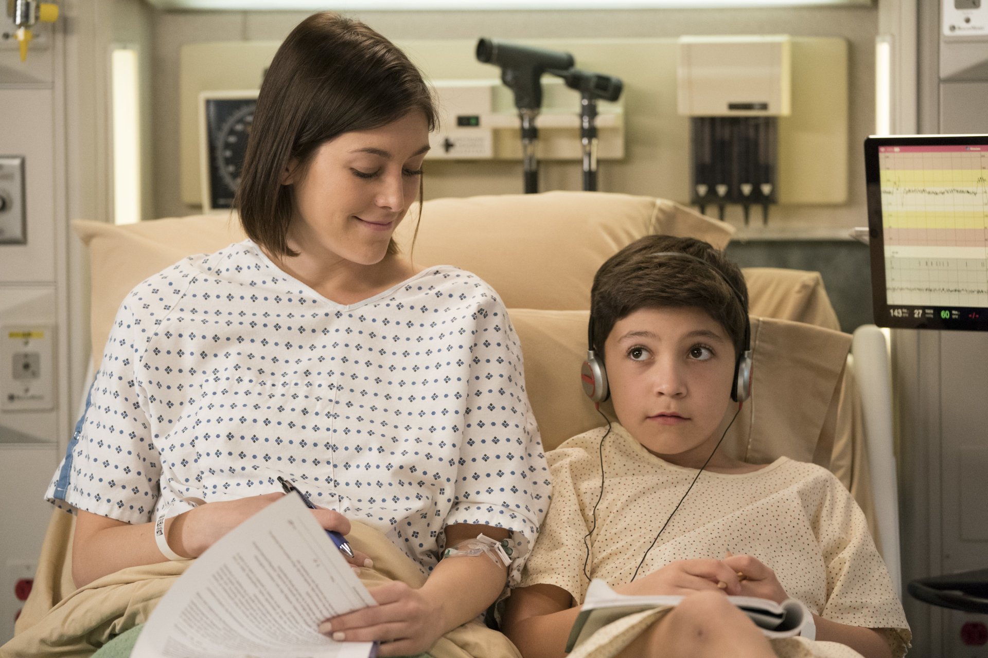 HD desktop wallpaper featuring a scene from the TV show Grey's Anatomy with a woman sitting beside a young patient in a hospital setting.