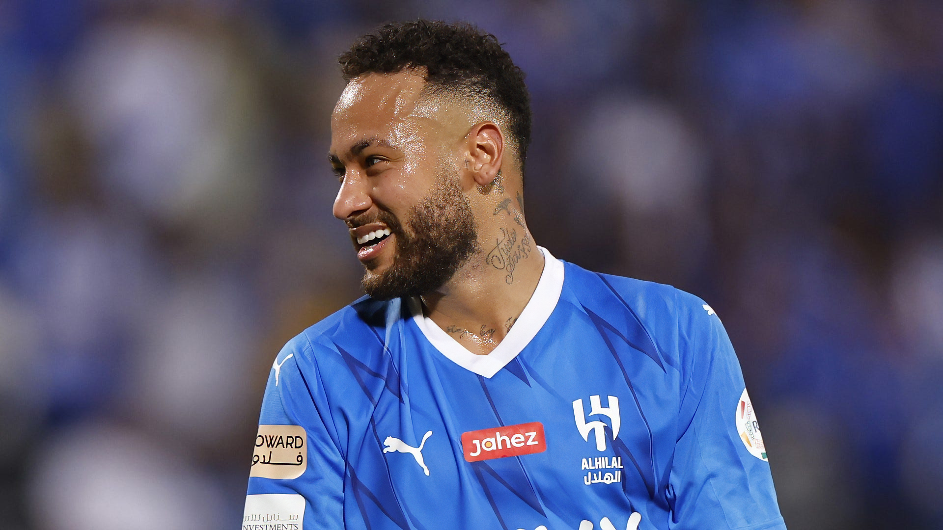 Soccer player in blue jersey smiling on the field, HD desktop wallpaper background