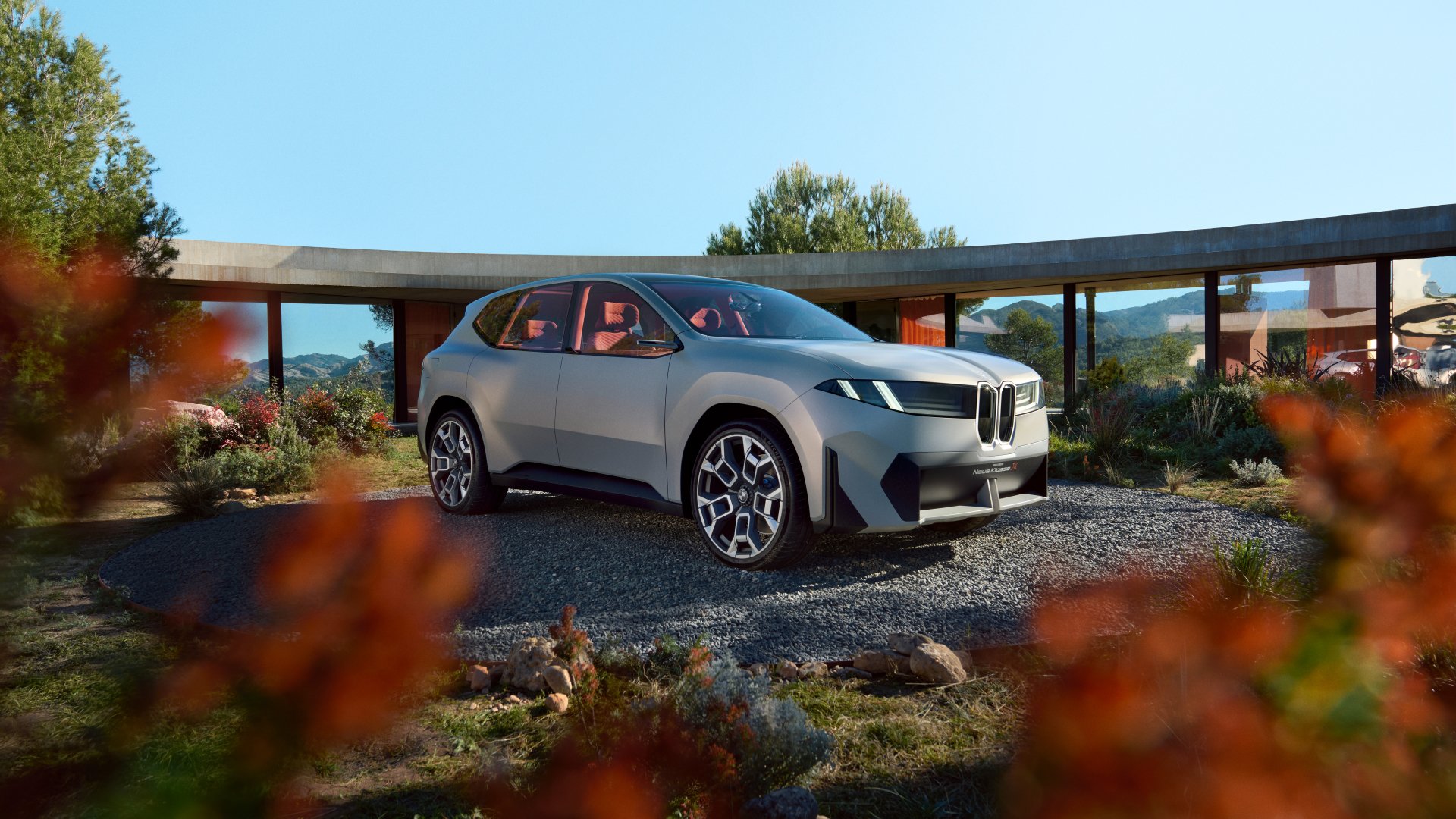 BMW Vision Neue Klasse X car showcased as an HD desktop wallpaper, staged in a picturesque outdoor setting with autumn foliage.