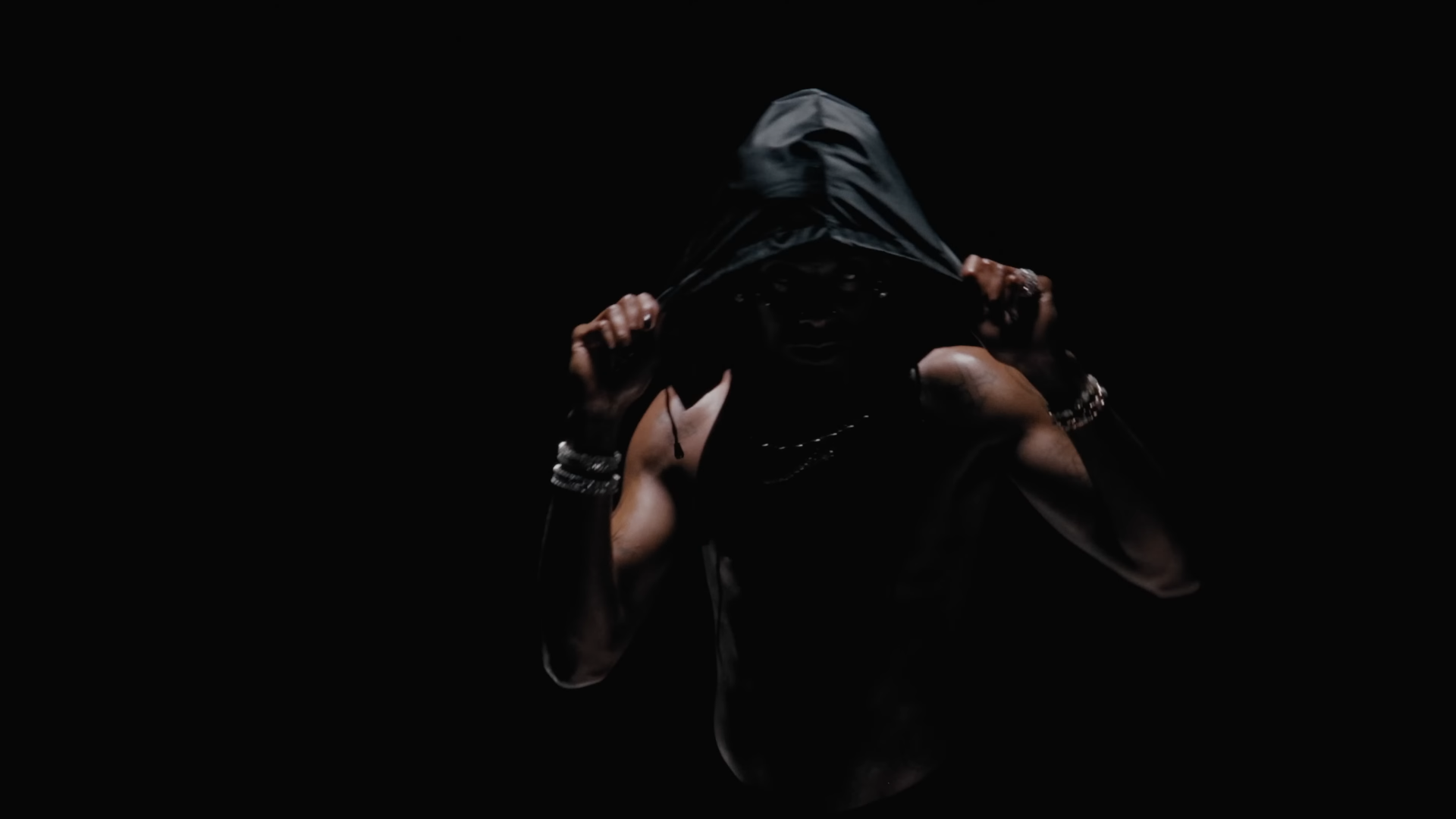 A dark, moody 4K Ultra HD PC desktop wallpaper featuring Playboi Carti with his hood partially covering his face, embodying a mysterious music vibe.