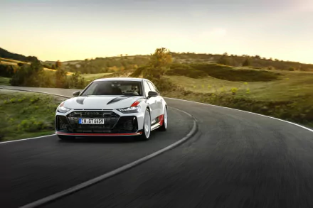 Audi RS6 Avant GT speeding along a curve on a scenic road, HD desktop wallpaper.