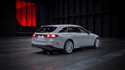 HD wallpaper of a Mercedes-AMG E53 Hybrid car showcased in a modern showroom, highlighting its sleek design and hybrid technology.