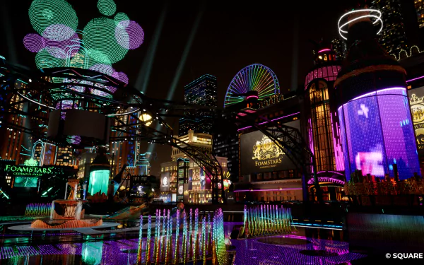 HD desktop wallpaper featuring a vibrant night scene from the video game Foamstars, with colorful lighting and futuristic architecture.