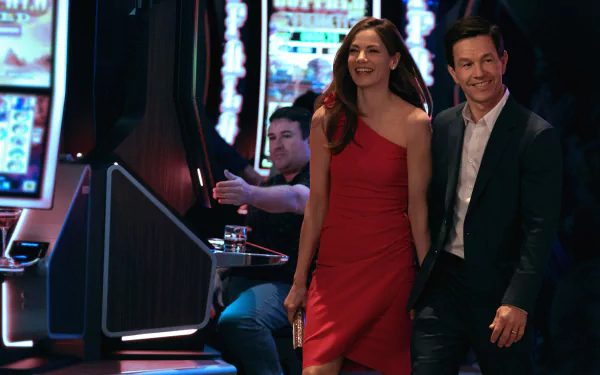 HD wallpaper from The Family Plan featuring a couple smiling in a casino setting.
