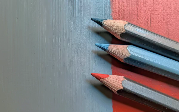 High-definition desktop wallpaper featuring a close-up of sharpened colored pencils on a textured red and grey background.