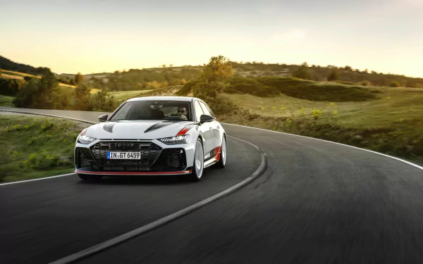 Audi RS6 Avant GT speeding along a curve on a scenic road, HD desktop wallpaper.