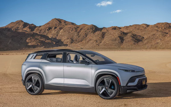 Silver Fisker Ocean electric vehicle on a desert landscape, showcasing stylish design for HD wallpaper.