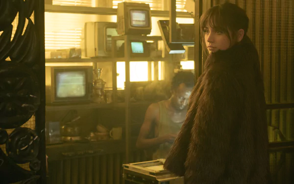HD desktop wallpaper featuring a scene from Blade Runner 2049 with a character in a fur coat inside a dimly lit room with vintage monitors.