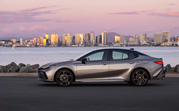 A silver Toyota Camry XSE parked with a city skyline in the background during twilight, used as an HD desktop wallpaper and background.