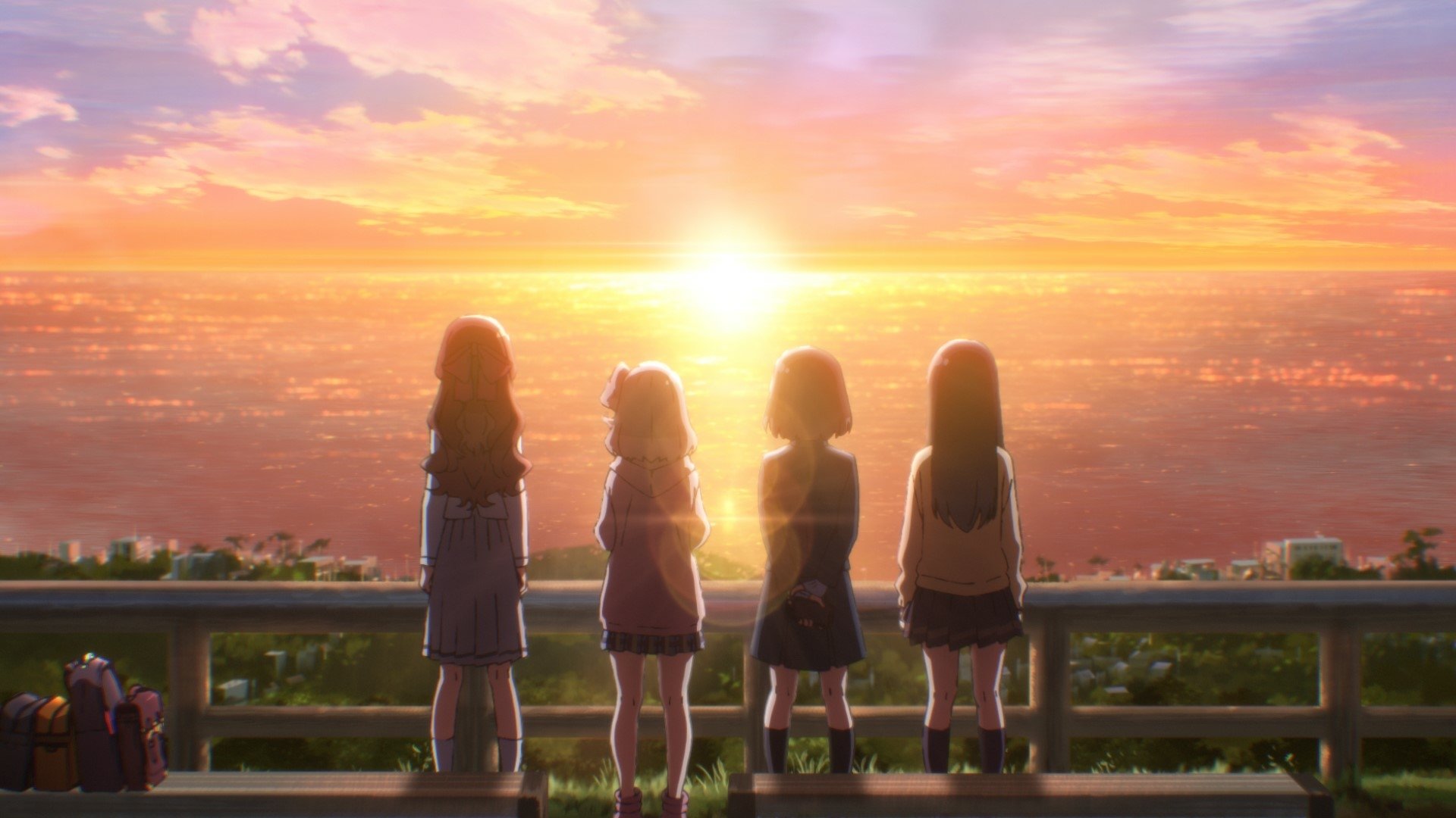 A stunning HD anime wallpaper featuring four girls gazing at a vibrant sunset over the ocean. The scene captures a moment of reflection and friendship against a colorful sky.