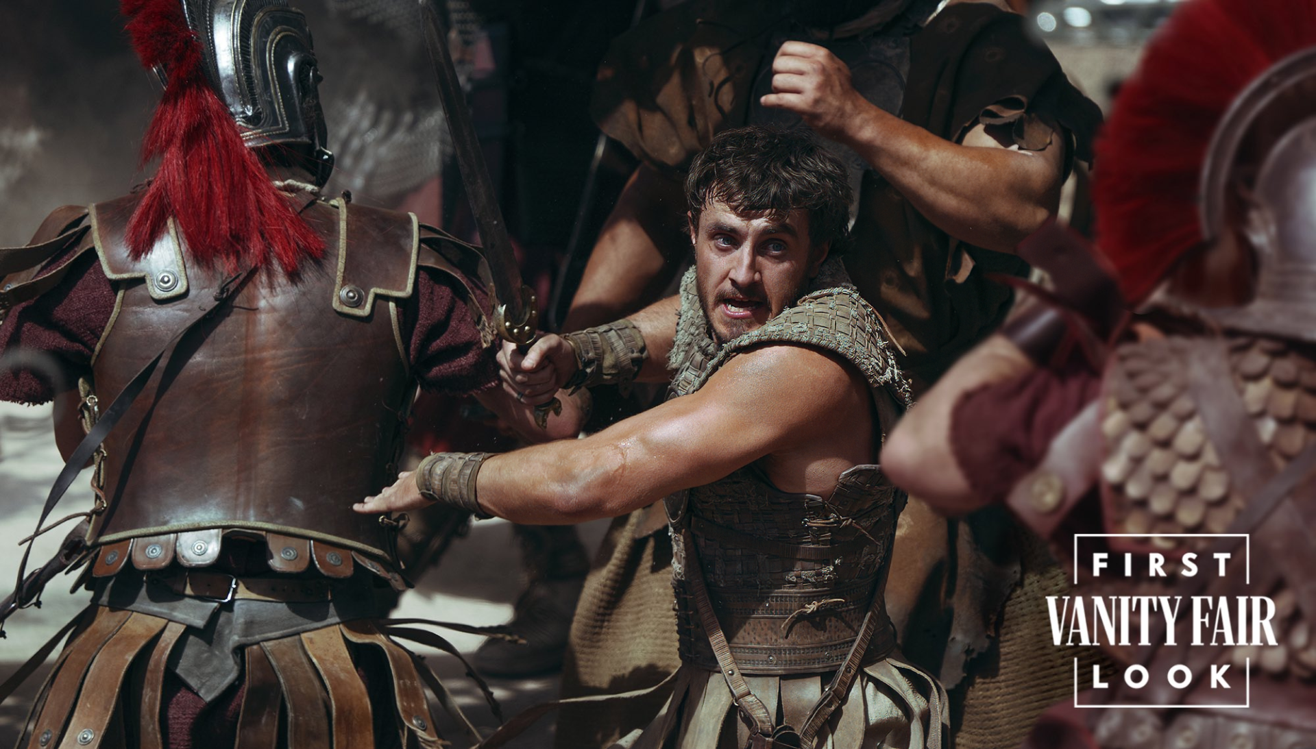 HD desktop wallpaper featuring a scene from Gladiator II, with intense battle and warriors in armor. The image is tagged with Vanity Fair’s first look.