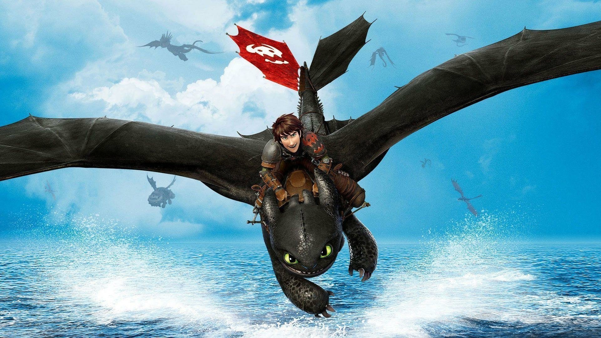 HD desktop wallpaper featuring Hiccup riding Toothless over the ocean with a red flag in the background from the movie How to Train Your Dragon. Other dragons can be seen in the distance against a blue sky.