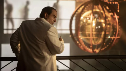 HD desktop wallpaper featuring Colin Farrell as The Penguin from a TV show, depicted in a thoughtful pose against a backdrop of a large, intricate clock.