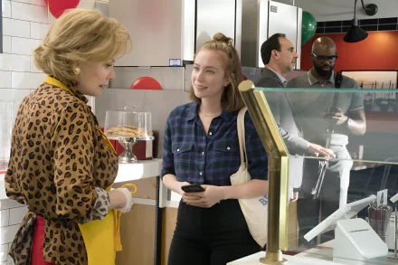 HD desktop wallpaper featuring a scene from the TV show Hacks (2021) with two characters talking in a lively cafe setting.