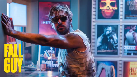 HD desktop wallpaper featuring a dynamic scene from the movie The Fall Guy with a male character in sunglasses and sleeveless top, positioned in a colorful room with movie posters.