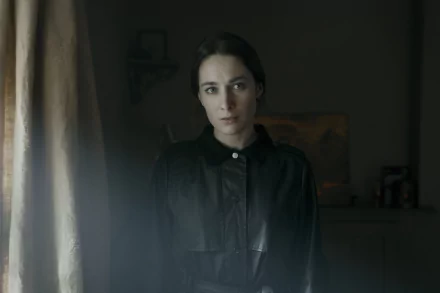 HD desktop wallpaper featuring a somber female character from the TV show Bodkin, set in a dimly-lit vintage room.