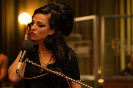 A high-definition desktop wallpaper from the movie Back to Black, featuring Amy Winehouse in a recording studio with her signature beehive hairstyle and makeup, singing into a microphone.