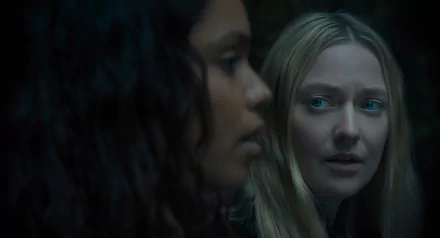 HD desktop wallpaper featuring a scene from the movie The Watchers (2024) with Dakota Fanning. The image showcases a close-up interaction between two characters in a dark and intense setting.