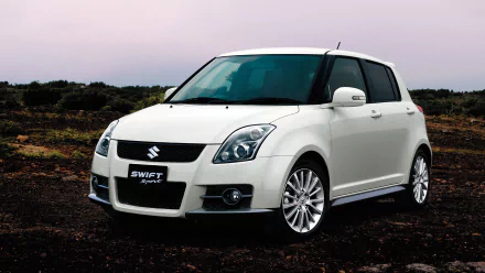 HD desktop wallpaper featuring a white Suzuki Swift Sport car parked on a rugged outdoor terrain under a soft, overcast sky.