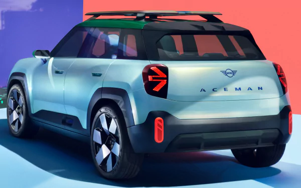 HD wallpaper featuring the rear view of a Mini Aceman car with a two-tone paint job, parked against a gradient blue and pink background.