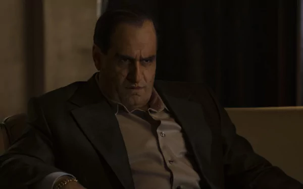HD desktop wallpaper featuring Colin Farrell as The Penguin in a TV show, depicted sitting pensively in a darkly lit room.
