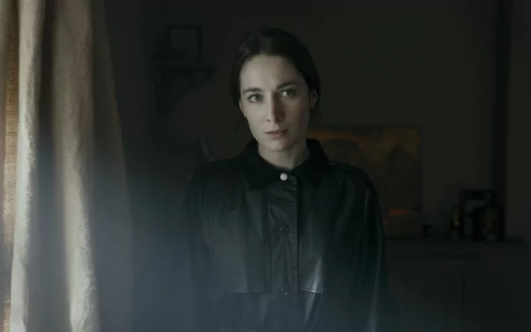 HD desktop wallpaper featuring a somber female character from the TV show Bodkin, set in a dimly-lit vintage room.