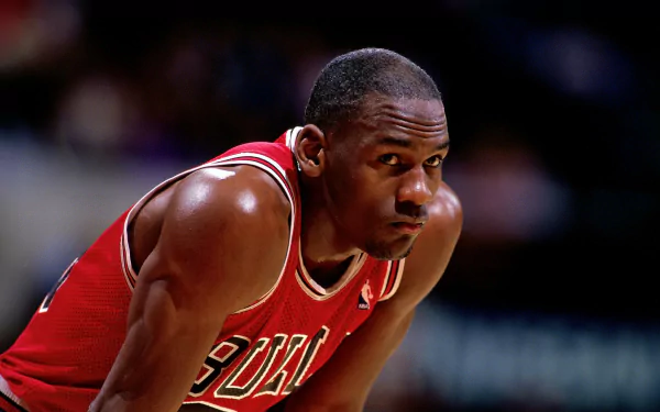 HD desktop wallpaper featuring NBA legend Michael Jordan in a Chicago Bulls uniform, showcasing his determination and focus on the basketball court.