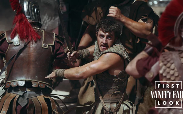 HD desktop wallpaper featuring a scene from Gladiator II, with intense battle and warriors in armor. The image is tagged with Vanity Fair’s first look.