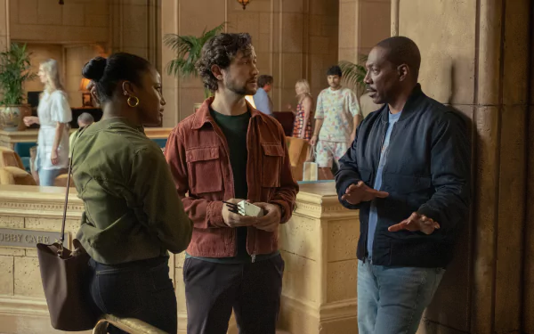 HD desktop wallpaper from the movie Beverly Hills Cop: Axel F, showing three individuals engaged in conversation in a lavish interior setting.