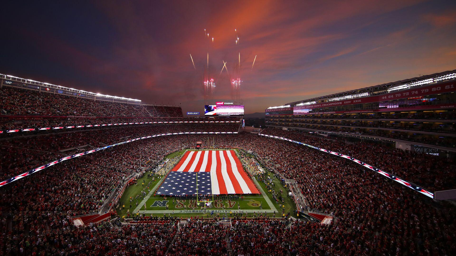 A vibrant San Francisco 49ers football game scene, showcasing a packed stadium under a stunning sunset, with an oversized American flag on the field and fireworks lighting the sky.